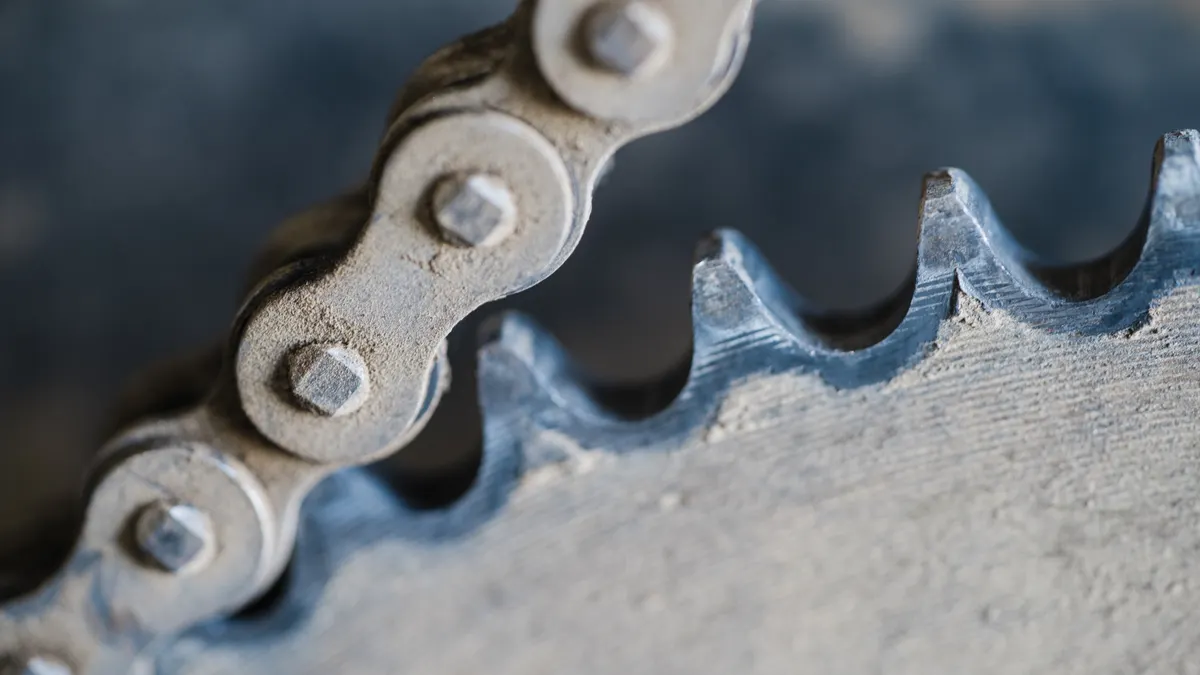 How to Choose the Right Trencher Chain and Teeth for Soil Conditions Extreme close-up of chain links beside toothed wheel