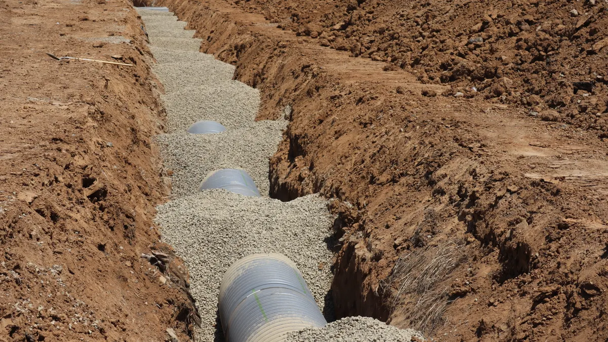 How to Plan a Multi-Utility Trench Layout for One Property Trench with pipes set in gravel bedding