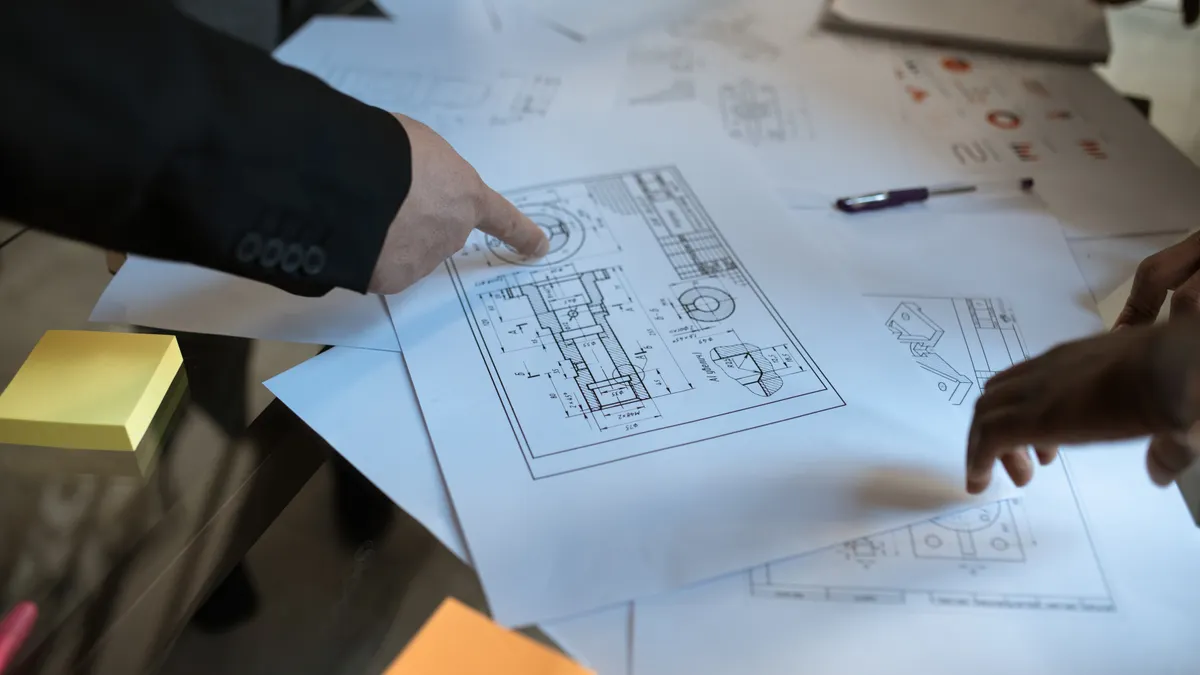 How to Plan a Trench for Future Utility Upgrades People reviewing a construction blueprint at a table